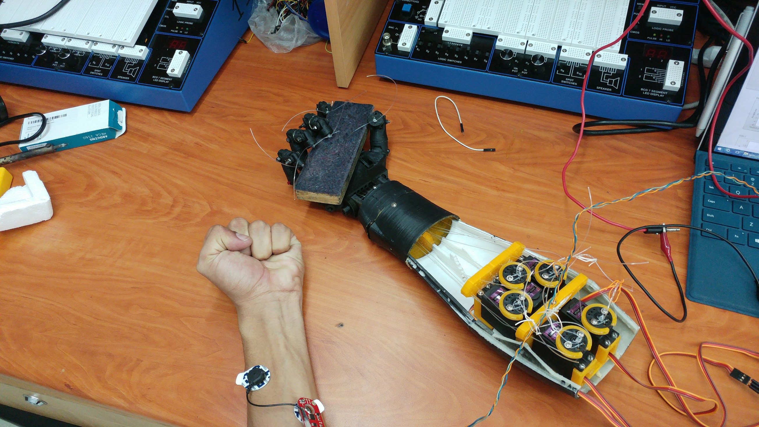 Arm prototype and EMG sensor connected to a user for testing.